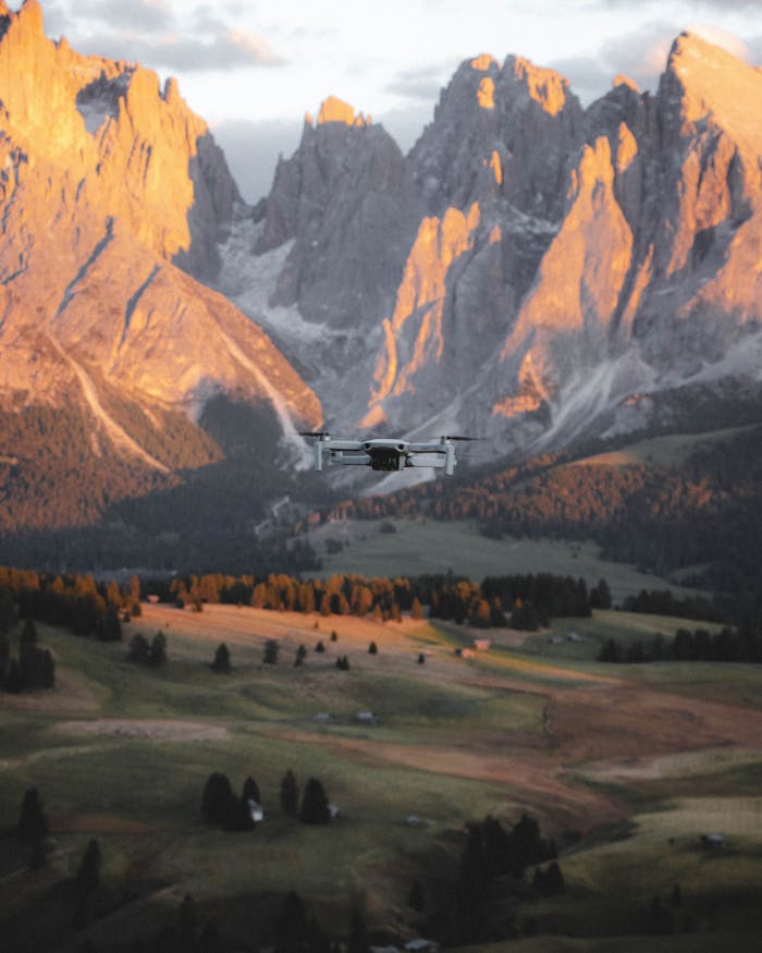 Aerial view of a drone flying over the picturesque Dolomites mountains in Italy during sunset.